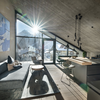 Sonniges Wohnzimmer mit Couch und großem Balkon mit Bergblick