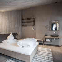 Schlafzimmer mit großem Doppelbett und Waschbecken