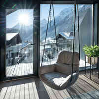 Wohnzimmer mit Hängesessel und großem Balkon mit Bergblick